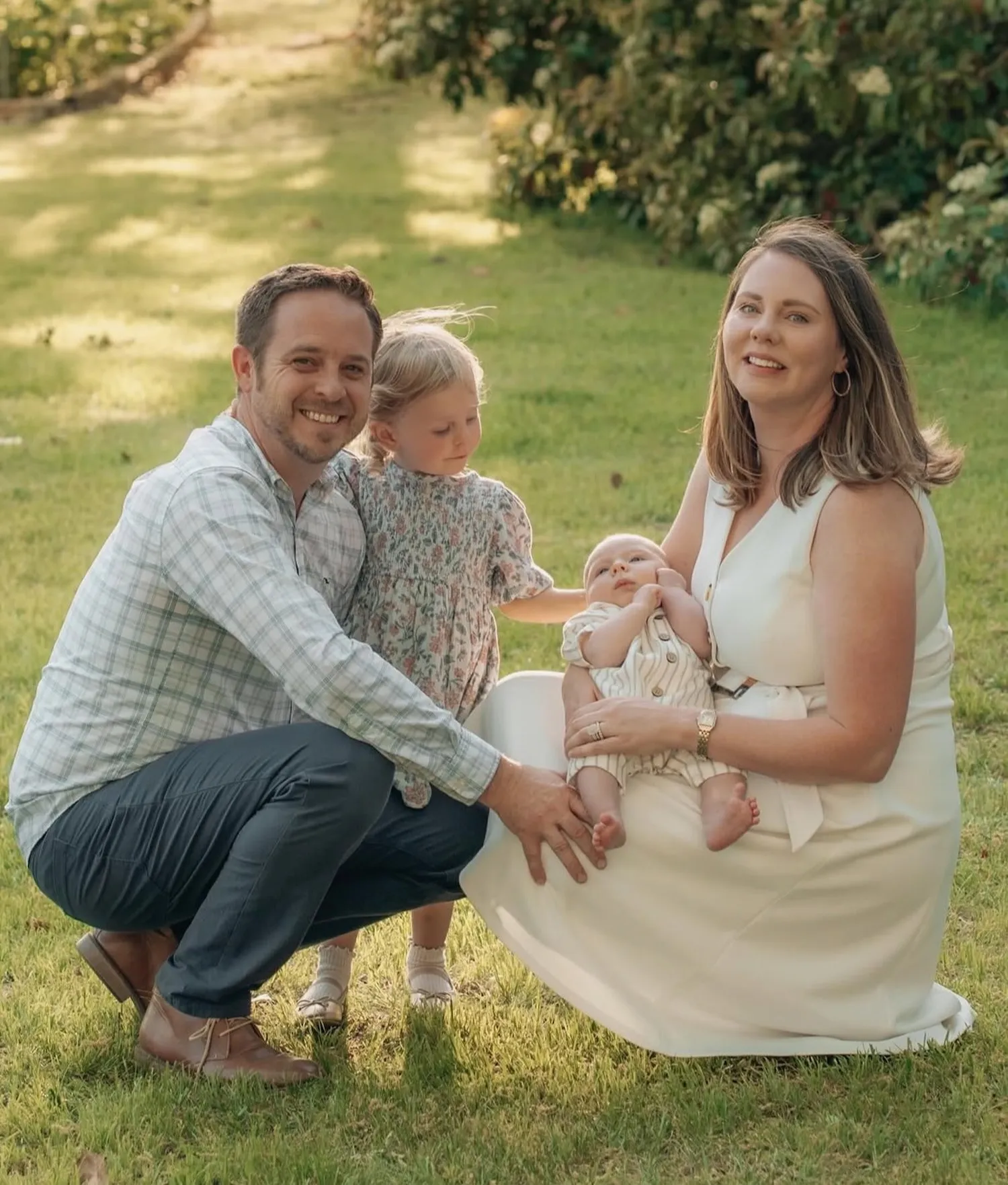 A family sitting together in a sunlit field at golden hour